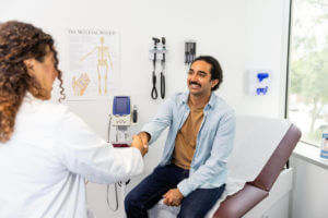 primary care doctor greets man with handshake